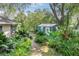 Charming backyard featuring a lush garden path and an outbuilding with a white door at 500 Lake Forest Cir, Mount Dora, FL 32757