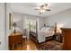 Charming bedroom features a four-poster bed, hardwood floors, and a ceiling fan at 500 Lake Forest Cir, Mount Dora, FL 32757