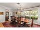 Formal dining room with a decorative chandelier, detailed woodwork, and large windows looking out to the yard at 500 Lake Forest Cir, Mount Dora, FL 32757