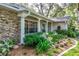 Home exterior with stone detailing, a covered porch, and mature landscaping at 500 Lake Forest Cir, Mount Dora, FL 32757