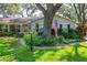 Charming home with lush front yard, mature landscaping, and an American flag at 500 Lake Forest Cir, Mount Dora, FL 32757