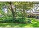 Mature landscaping of a home featuring lots of grass, trees, and a manicured garden at 500 Lake Forest Cir, Mount Dora, FL 32757