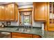 Kitchen sink with window view of the pool, granite countertops, custom wood cabinets and stainless steel appliances at 500 Lake Forest Cir, Mount Dora, FL 32757