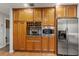 Well-organized kitchen with wood cabinets, stainless steel appliances including a wine rack and a granite countertop at 500 Lake Forest Cir, Mount Dora, FL 32757