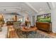 Spacious living room featuring hardwood floors, access to kitchen and backyard, a TV, and a ceiling fan for added comfort at 500 Lake Forest Cir, Mount Dora, FL 32757