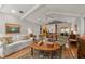 Bright living room with a ceiling fan, hardwood floors, and open access to the kitchen and backyard for seamless indoor-outdoor living at 500 Lake Forest Cir, Mount Dora, FL 32757