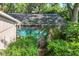 Tranquil backyard featuring a screened-in pool surrounded by lush greenery at 500 Lake Forest Cir, Mount Dora, FL 32757
