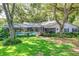 Backyard with a refreshing screened-in pool area surrounded by mature trees at 500 Lake Forest Cir, Mount Dora, FL 32757