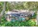 A beautiful screened-in pool area with lush greenery, creating a private and relaxing outdoor oasis at 500 Lake Forest Cir, Mount Dora, FL 32757