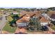 Aerial view of a home featuring a red tile roof, brick driveway, mature landscaping, and a two-car garage at 5046 Harbour Dr, Oxford, FL 34484