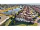 Stunning aerial view of a residential community with red tile roofs, lush landscaping, and a tranquil lake with a fountain at 5046 Harbour Dr, Oxford, FL 34484