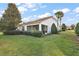 Lush backyard featuring a screened-in lanai, green lawn, and mature landscaping, perfect for outdoor living at 5046 Harbour Dr, Oxford, FL 34484