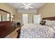Bedroom featuring a ceiling fan, wood floors, queen bed, dresser, and a light beige color scheme at 5046 Harbour Dr, Oxford, FL 34484
