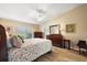 Bedroom with a ceiling fan, wood floors, dresser, and a queen bed with decorative linens at 5046 Harbour Dr, Oxford, FL 34484