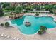 Aerial view of a resort-style community pool with waterfalls, lush landscaping, and plenty of lounge chairs at 5046 Harbour Dr, Oxford, FL 34484