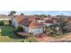 Well-maintained home with a red tile roof, brick driveway, lush landscaping, and a spacious two-car garage at 5046 Harbour Dr, Oxford, FL 34484