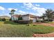 Charming single-story home featuring a well-manicured lawn, mature landscaping, and a brick-paved driveway at 5046 Harbour Dr, Oxford, FL 34484