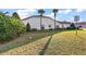 Expansive front yard showcasing lush green grass, mature shrubs, and palm trees, offering a serene landscape at 5046 Harbour Dr, Oxford, FL 34484