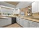 Bright eat-in kitchen with white cabinets, tile floors, and a pass through window to living room at 5046 Harbour Dr, Oxford, FL 34484
