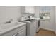 Functional laundry room featuring a utility sink, modern washer and dryer, and white cabinets for storage at 5046 Harbour Dr, Oxford, FL 34484