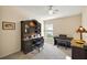 Comfortable home office featuring a large desk with hutch and a digital piano and bench, with natural light from a window at 5046 Harbour Dr, Oxford, FL 34484