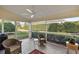 Inviting screened patio with comfortable wicker seating, ceiling fan, and view of the landscaped backyard at 5046 Harbour Dr, Oxford, FL 34484