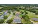 Aerial view showcasing the home's location within the community and its proximity to a pond and golf course at 5090 Greens Dr, Lady Lake, FL 32159