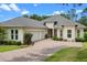 Inviting single-story home with a manicured lawn and a brick driveway leading to a two-car garage, embodying curb appeal at 5090 Greens Dr, Lady Lake, FL 32159