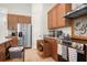 Kitchen with stainless steel appliances, granite countertops, and wood cabinets with convenient pull-out drawers for storage at 5090 Greens Dr, Lady Lake, FL 32159