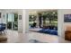 Open-concept living room with tile flooring and large sliding glass doors leading to a screened patio with green views at 5090 Greens Dr, Lady Lake, FL 32159