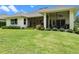 Charming exterior of home with screened lanai and lush greenery at 5090 Greens Dr, Lady Lake, FL 32159
