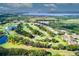 Scenic aerial view of golf course, lush landscaping, water features, and neighborhood homes at 52 Camino Real Blvd, Howey In The Hills, FL 34737