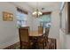 Dining room with a wooden table and chairs, decorative rug, chandelier and large windows at 52 Camino Real Blvd, Howey In The Hills, FL 34737