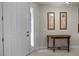 Inviting entryway featuring tile flooring, console table with art, and a bright white front door at 52 Camino Real Blvd, Howey In The Hills, FL 34737