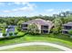 Beautiful two-story home with a lush landscaped lawn and screened-in balconies on the upper and lower floors at 52 Camino Real Blvd, Howey In The Hills, FL 34737