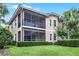 Exterior view of a two-story house with a screened-in lanai and well-maintained lawn at 52 Camino Real Blvd, Howey In The Hills, FL 34737