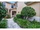 Inviting front entrance with well-manicured landscaping and a stone pathway leading to the front door at 52 Camino Real Blvd, Howey In The Hills, FL 34737