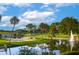 Scenic golf course with a water feature, lush landscaping, and blue sky, providing a tranquil and beautiful environment at 52 Camino Real Blvd, Howey In The Hills, FL 34737