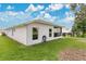 The backyard of the house has lush green grass, a garden, and an area for sitting at 5562 Charleston Avenue, Tavares, FL 32778