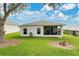 View of backyard with the home's screened-in lanai with a well maintained lawn at 5562 Charleston Avenue, Tavares, FL 32778