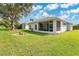 The backyard boasts a well-maintained lawn and a screened-in lanai perfect for enjoying the outdoors at 5562 Charleston Avenue, Tavares, FL 32778