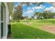 The backyard offers a beautifully landscaped lawn with trees and lush greenery at 5562 Charleston Avenue, Tavares, FL 32778