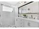 Modern bathroom featuring double sinks, shower with glass door, and large framed mirror at 5562 Charleston Avenue, Tavares, FL 32778
