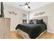 Comfortable bedroom with decorative wall art, ceiling fan, and view of the outdoors at 5562 Charleston Avenue, Tavares, FL 32778