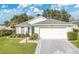 Beautiful single-story home with a patterned driveway, well-manicured lawn, and mature landscaping at 5562 Charleston Avenue, Tavares, FL 32778