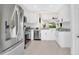 Bright kitchen with stainless steel appliances, white cabinetry, and modern tile flooring at 5562 Charleston Avenue, Tavares, FL 32778