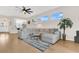 Cozy living room with light hardwood floors, a large sectional sofa, and lots of natural light at 5562 Charleston Avenue, Tavares, FL 32778