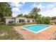 A backyard view shows a large rectangular pool with brick patio and lush green lawn at 6665 Lake Cane Dr, Orlando, FL 32819