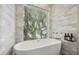 Bright bathroom featuring a modern tub with a view and tiled wall at 6665 Lake Cane Dr, Orlando, FL 32819