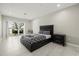 Bright bedroom with a view, featuring tile floors, a patio, and a sleek, dark-framed bed at 6665 Lake Cane Dr, Orlando, FL 32819